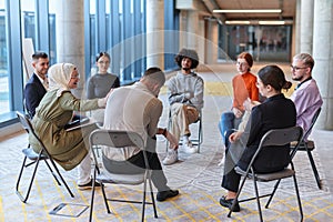 A diverse group of young business entrepreneurs gathered in a circle for a meeting, discussing corporate challenges and