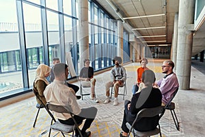 A diverse group of young business entrepreneurs gathered in a circle for a meeting, discussing corporate challenges and