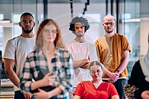 A diverse group of young business people walking a corridor in the glass-enclosed office of a modern startup, including