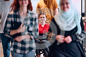 A diverse group of young business people walking a corridor in the glass-enclosed office of a modern startup, including