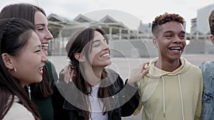 Diverse group of young friends laughing and having fun together outdoors