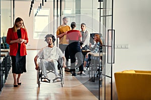 A diverse group of young professionals, including businesswomen and an African-American entrepreneur in a wheelchair