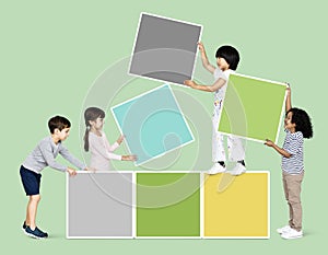 Diverse happy kids stacking empty square boards