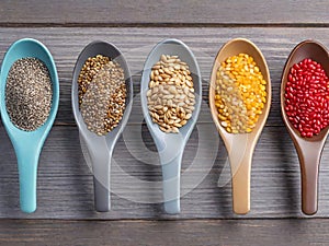 Diverse Harvest: Top View Spoon with Seeds, Row of Spoons with Grains.