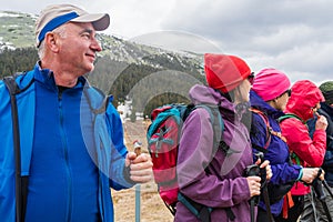 Diverse hikers with backpacks and nordic walking sticks