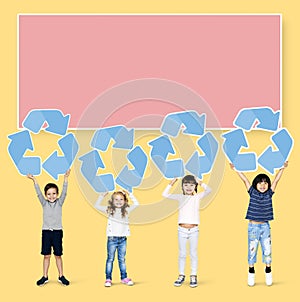 Diverse kids holding recycling icons