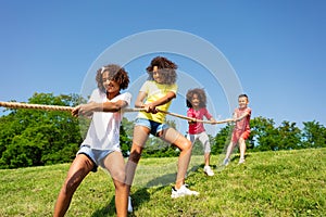 Diverse kids pull rope - competitive fun park game