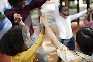 Diverse kindergarten students hands up together photo