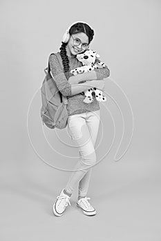 Diverse learning environments designed to meet the needs. Teen with backpack. Cute smiling schoolgirl carry soft toy dog