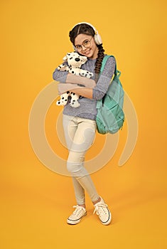 Diverse learning environments designed to meet the needs. Teen with backpack. Cute smiling schoolgirl carry soft toy dog