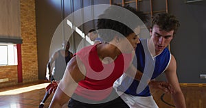 Diverse male basketball team and coach practice dribbling ball