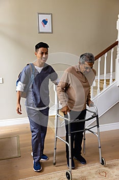 Diverse male doctor and senior male patient with crutches at home