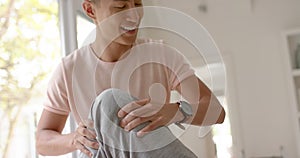 Diverse male physiotherapist advising and senior male patient exercising on couch, in slow motion