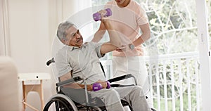 Diverse male physiotherapist advising and senior man in wheelchair using dumbbells, in slow motion