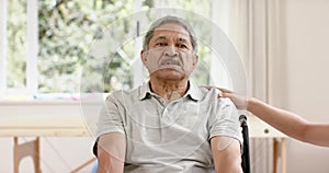 Diverse male physiotherapist advising and senior man in wheelchair using dumbbells, in slow motion