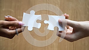 Diverse man and woman hands holding joining pieces connecting puzzle