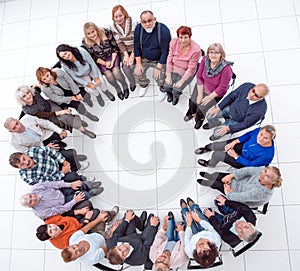 diverse mature people sitting in a circle and showing their unity