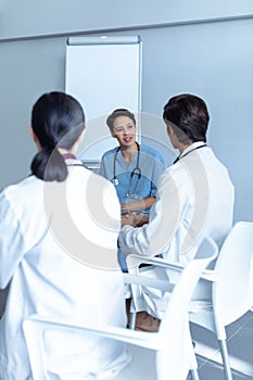 Diverse medical team sitting and discussing at the table