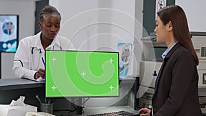 Diverse medical team using computer with greenscreen