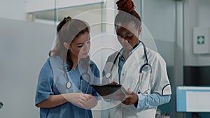 Diverse medical team using digital tablet for information