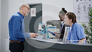 Diverse medical team working at hospital registration counter in lobby