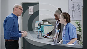 Diverse medical team working at hospital registration counter in lobby