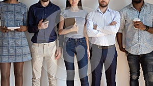 Diverse millennial people stand in row at office together