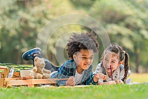 Diverse mixed race kids as friends have fun together during picnic in park