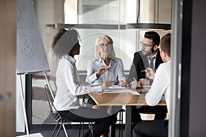 Diverse multiethnic colleagues talk brainstorming at office meeting