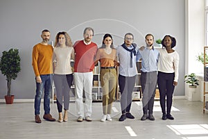 Diverse multiethnic group of adults and young people hug standing in line