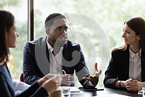 Diverse multiracial colleagues discuss ideas at briefing