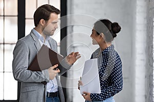 Diverse office colleagues met in office talking discussing project ideas