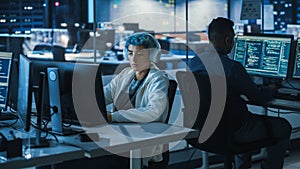 Diverse Office at Night: Multi-Ethnic Team of Young Programmers Working on Computers, Screens Show