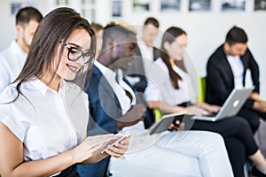 Diverse office people working on mobile phones, corporate employees holding smartphones at meeting. Serious multiracial