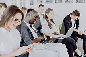 Diverse office people working on mobile phones, corporate employees holding smartphones at meeting. Serious multiracial