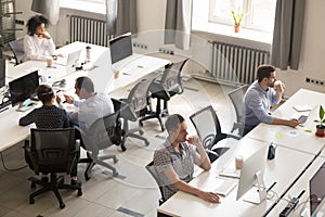 Diverse office workers using computers in modern corporate space