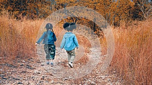 Diverse people of asian and african american children having fun walking and playing together in natural park in autumn