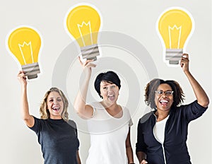 Diverse people carrying light bulb icons