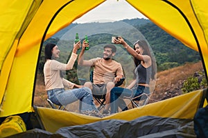 Diverse people of caucasian and asian friends having fun together traveling and camping at natural park in summer