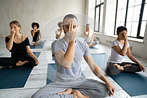 Diverse people doing Alternate Nostril Breathing exercise, practicing yoga