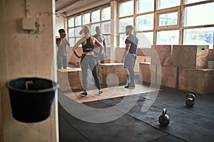 Diverse people doing box jumps during a gym workout