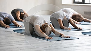 Diverse people doing child exercise at group lesson, practicing yoga