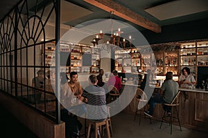 Diverse people enjoying drinks at a bar in the evening