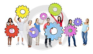 Diverse People Holding Colorful Cogs