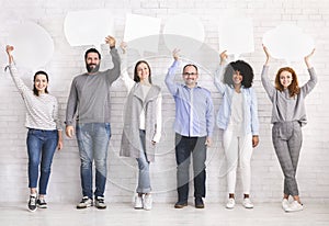 Diverse people holding empty speech bubbles above their heads, free space