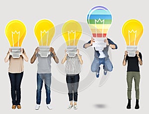 Diverse people holding light bulb icons