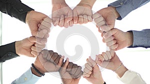 Diverse people holding their fists together in the office