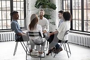 Diverse people sit in circle participate in group session