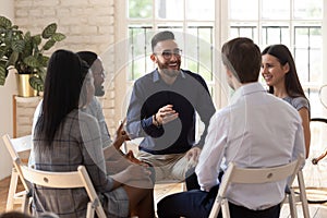 Diverse people sit in circle participating in team building activity