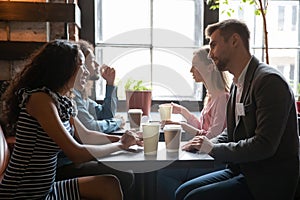 Diverse people sitting in cafe, participating in speed dating photo